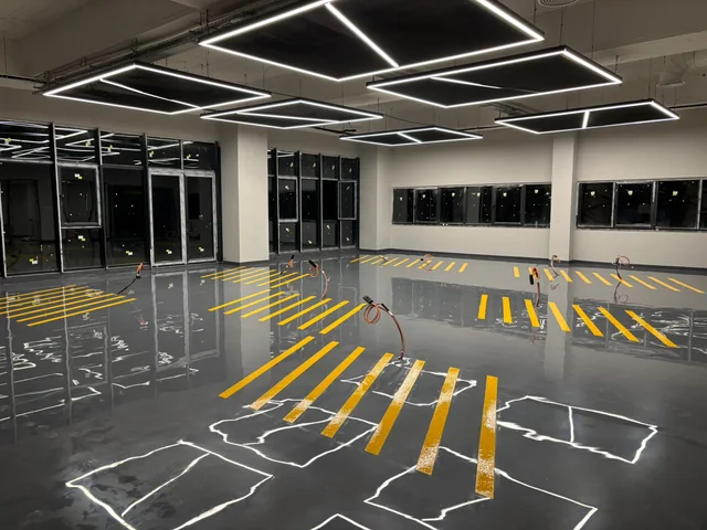 Gri epoksi yüzey üzerinde sarı yönlendirme çizgileri bulunan otopark
